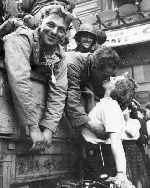 Vintage black and white image of a solider kissing a woman.